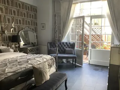 a bedroom with a bed and a chair and a mirror at A Room in the City - West in Edinburgh