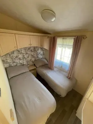 two beds in a small room with a window at Willerby Granada 2-Bedroom Located in Uddingston, Glasgow at Maryville Caravan Site in Uddingston