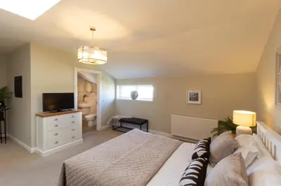 a bedroom with a large bed and a television at Arran View Apartment at Heads of Ayr in Ayr