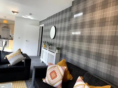 a living room with two couches and a wall at Modern 2 bedroom flat with free parking in Cambuslang, Glasgow in Glasgow