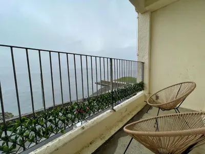 a balcony with two chairs and a view of the ocean at A Shore Stay in Gourock