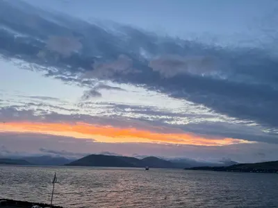 a sunset over a large body of water at A Shore Stay in Gourock