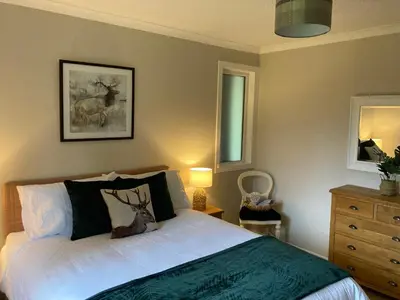 a bedroom with a bed and a dresser at Cedar Lodge in Oban