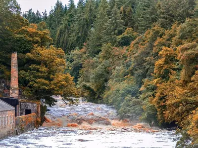 a river with snow on it in a forest at Castlegate in Lanark
