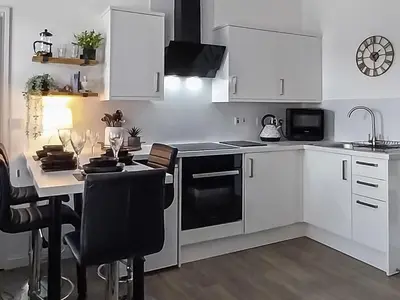 a kitchen with white cabinets and a black stove top oven at Castlegate in Lanark