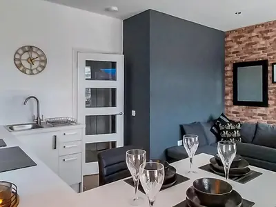 a kitchen and living room with a table with wine glasses at Castlegate in Lanark