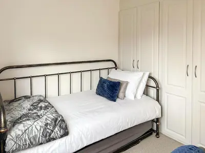 a bed with white sheets and blue pillows on it at Castlegate in Lanark