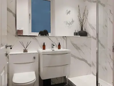 a white bathroom with a toilet and a sink at Castlegate in Lanark