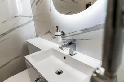 a bathroom with a white sink and a mirror at One Bed Holiday Home in the Heart of Glasgow in Glasgow