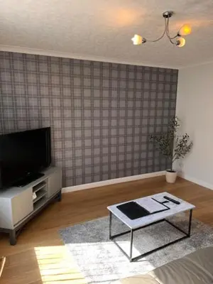 a living room with a tv and a coffee table at Kelpies Serviced Apartments- McLaughlan in Falkirk