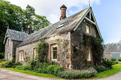 an old stone house with ivy growing on it at The Stables in Castle Douglas