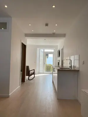 a kitchen with white walls and a wooden floor at Hugmish in Tighnabruaich