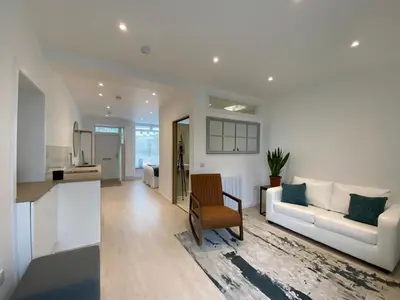 a living room and kitchen with a white couch at Hugmish in Tighnabruaich
