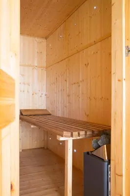 a wooden sauna with a wooden bench in it at Stunning 4-Bedroom Country House with Hot Tub & Sauna near Loch Lomond in Glasgow