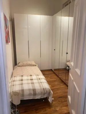 a small bedroom with a bed and a mirror at Lovely main door 2 bed apartment in Edinburgh