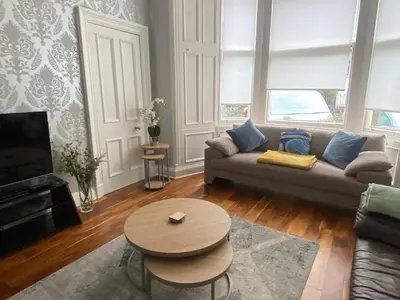 a living room with a couch and a table at Lovely main door 2 bed apartment in Edinburgh