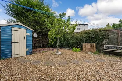 a garden with a blue shed and a tree at Centrally Situated 1 Bedroom House in Cumbernauld in Cumbernauld