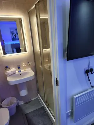 a small bathroom with a sink and a shower at Crosskeys Edinburgh in Edinburgh