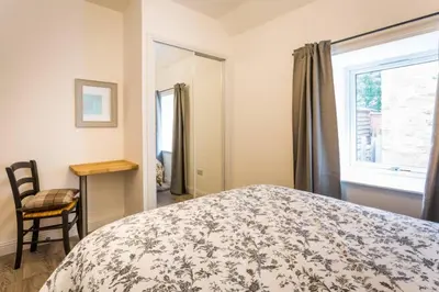 a bedroom with a bed and a window and a chair at Ideal Couples base for exploring the Isle of Arran in Shiskine