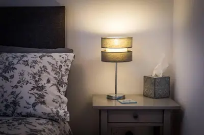a lamp on a night stand next to a bed at Ideal Couples base for exploring the Isle of Arran in Shiskine