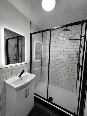 a white bathroom with a sink and a shower at Amani Apartments - Glasgow City Centre in Glasgow