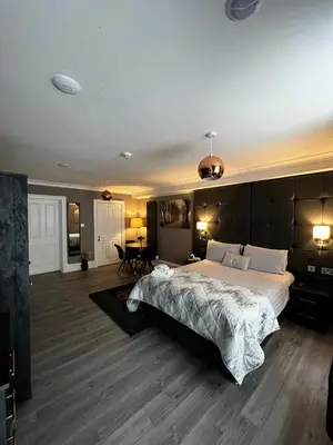 a large bedroom with a large bed and wooden floors at Amani Apartments - Glasgow City Centre in Glasgow