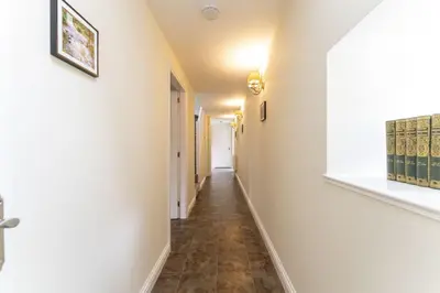 a hallway with white walls and a tile floor at Garden Cottage in Gargunnock