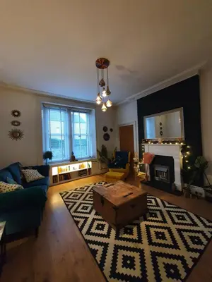 a living room with a couch and a table at The Flat with the Pink Door in Edinburgh