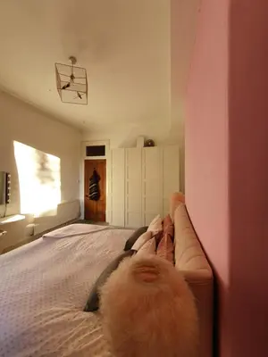 a dog laying on a bed in a bedroom at The Flat with the Pink Door in Edinburgh