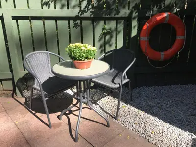 a table with two chairs and a potted plant on it at Riverside Loft in Barcaldine