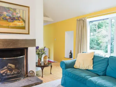 a living room with a blue couch and a fireplace at Tigh Nam Muc in Loanhead