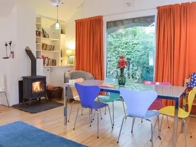 a dining room with a table and chairs and a fireplace at Tigh Nam Muc in Loanhead