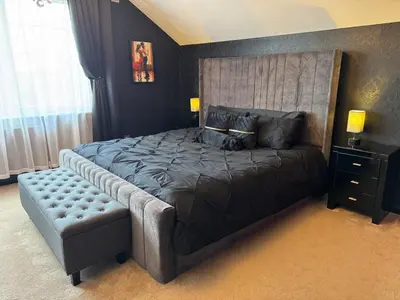 a bedroom with a large bed with a large headboard at FINN VILLAGE Loch Lomond Villa - THE BLACK ROOM with Private Jacuzzi-Style Bath in Drymen