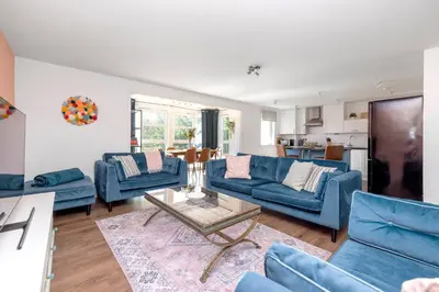 a living room with blue couches and a table at JOIVY Modern 2 bed flat near Murrayfield Stadium in Edinburgh