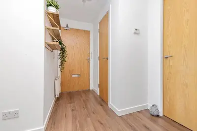 an empty hallway with a door and wooden floors at JOIVY Modern 2 bed flat near Murrayfield Stadium in Edinburgh