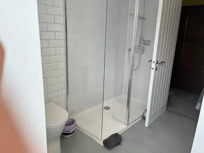a shower with a glass door in a bathroom at St John's Town of Dalry Glentress Apartment 1 in Dalry