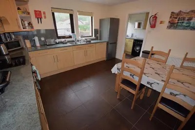 a kitchen with a table and a dining room at Ridgeview Villa - Partial loch view in Lochgoilhead