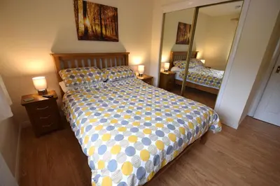 a bedroom with a bed and a large mirror at Ridgeview Villa - Partial loch view in Lochgoilhead