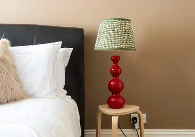 a red lamp sitting on a table next to a bed at Super central Edinburgh Castle basement in Edinburgh