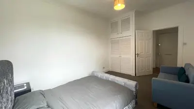 a bedroom with a bed and a blue chair at 2 Bedrooms Entire Apartment Self Check in in Fife