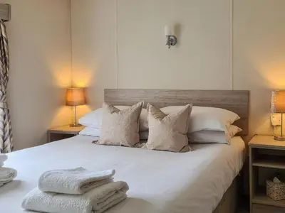 a bedroom with a bed with white sheets and pillows at Castle Campbell View in Dollar