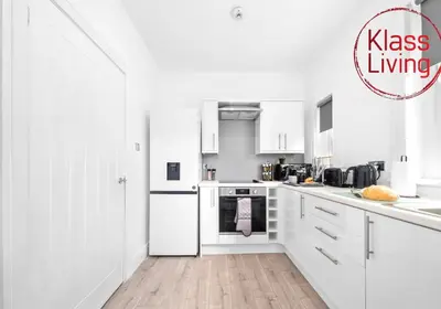 a white kitchen with white cabinets and appliances at Sanderson Apartment by Klass Living Uddingston in Uddingston