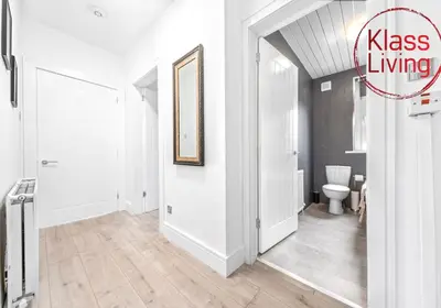 a bathroom with a toilet and a door with a sign that reads kiss living at Sanderson Apartment by Klass Living Uddingston in Uddingston
