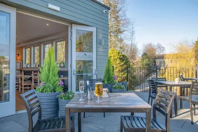 a patio with a wooden table and chairs at The Woodside in Doune