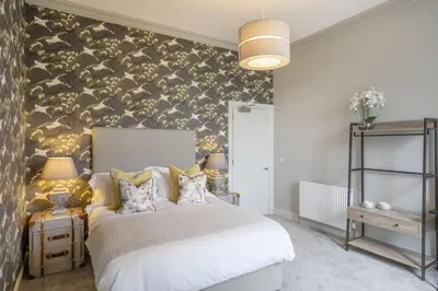 a bedroom with a bed and a wall covered in animal prints at The Woodside in Doune