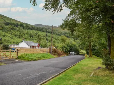 a road with a car parked on the side of the road at Beechwood in Arrochar
