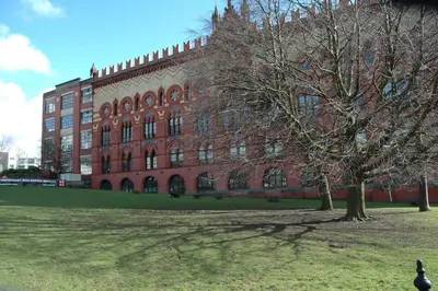 a large red brick building with a tree in front of it at The Nelson - Spacious City Property and Free Parking in Glasgow