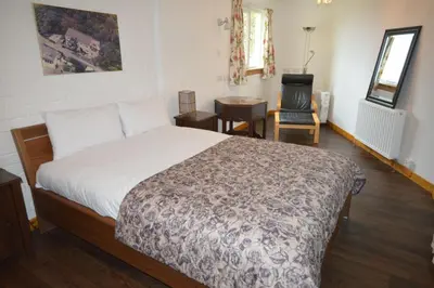 a bedroom with a bed and a desk and a chair at Ardura Apartment No 1 in Oban