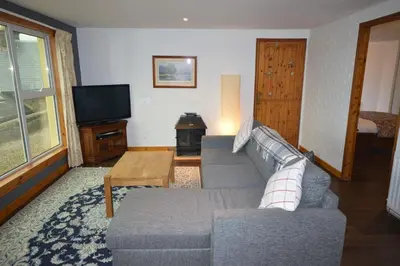 a living room with a couch and a tv at Ardura Apartment No 1 in Oban
