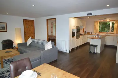 a living room with a couch and a kitchen at Ardura Apartment No 1 in Oban